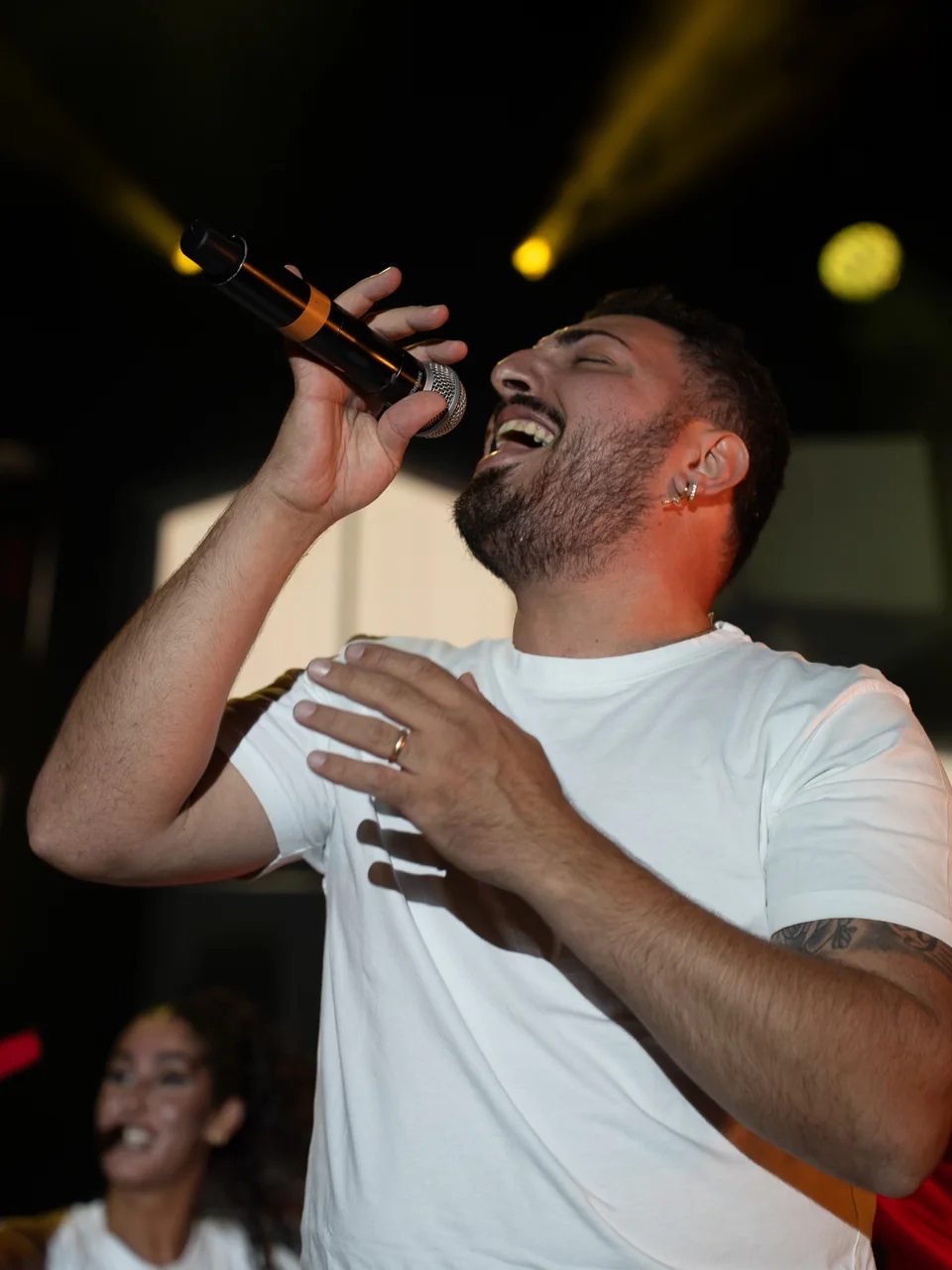 Alfonso Giorno canta al microfono sotto le luci del palco